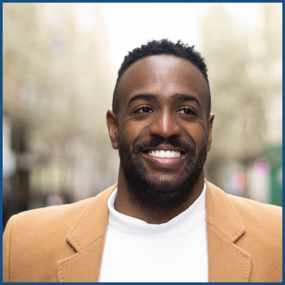 a black man outside smiling